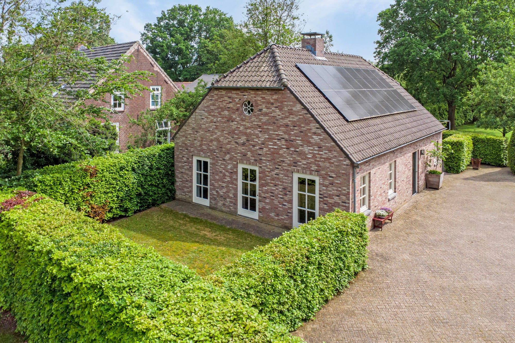 De Kookstudio, een vrijstaand bakstenen gebouw tussen groene hagen