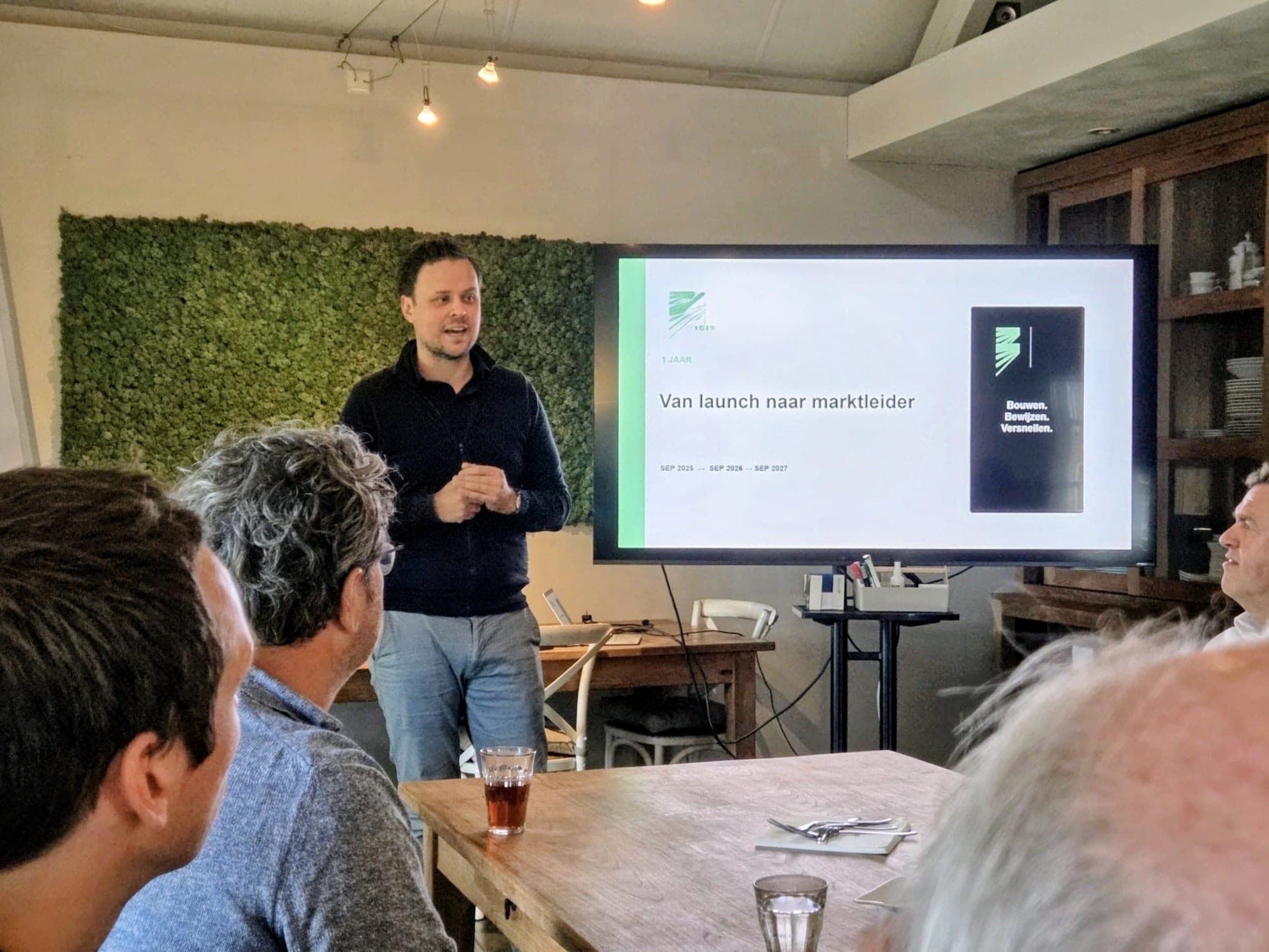 Een spreker presenteert voor een groep bij het scherm