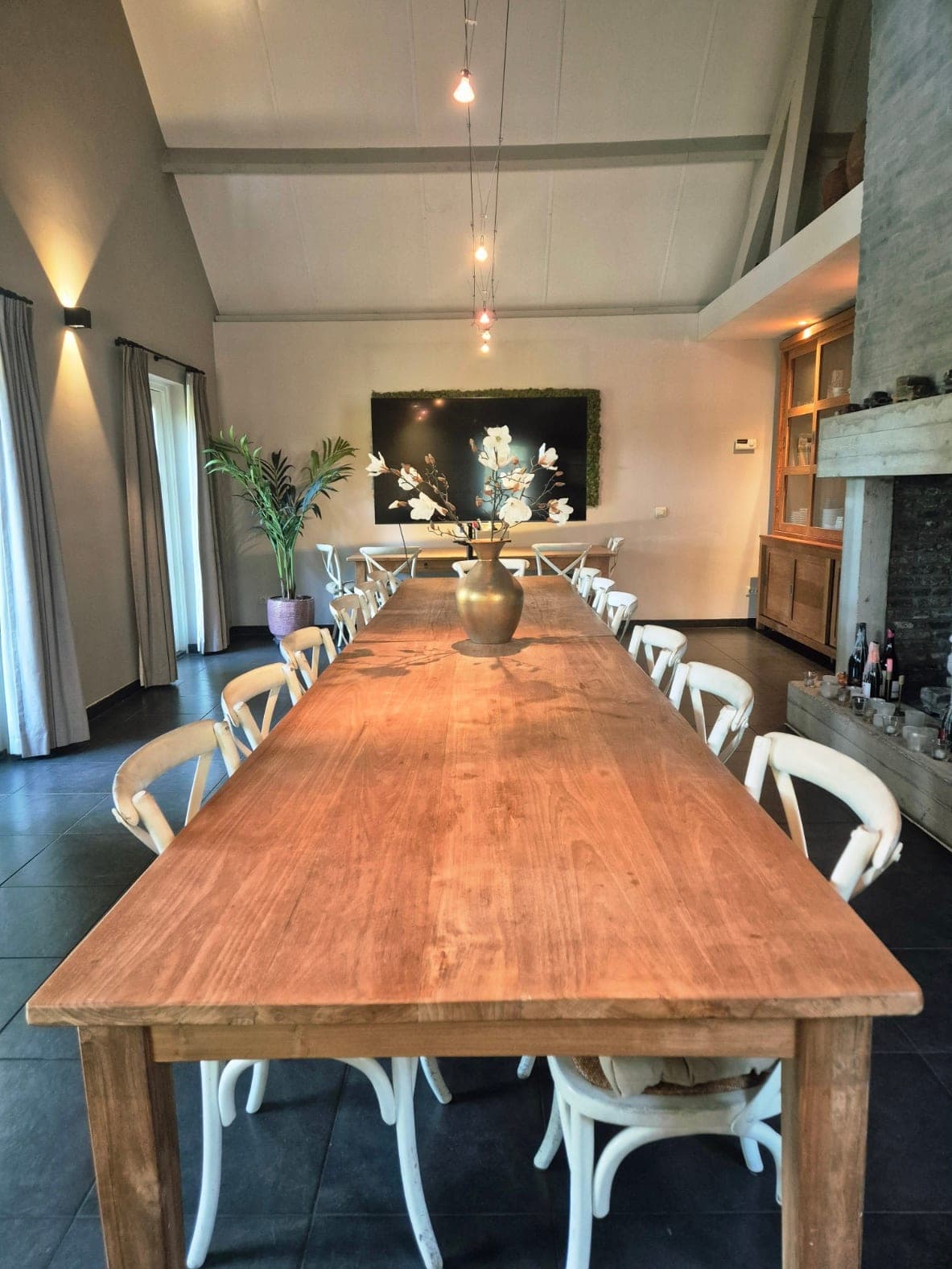 De lange houten tafel met stoelen in de lichte ruimte